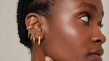 Woman wearing a gold ear cuff and crystal cartilage earrings part of Astrid & Miyu's best selling earrings collection.