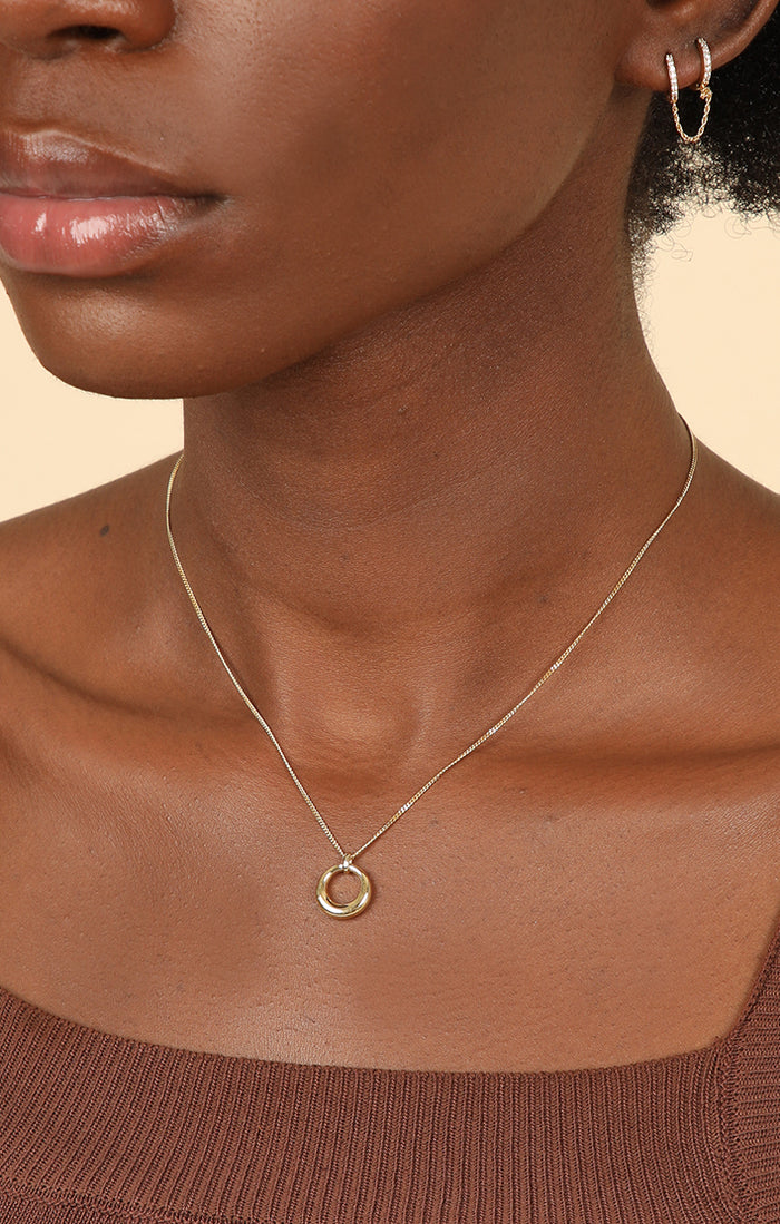 Woman wearing a minimalist silver snake chain with a silver necklace pendant for a simple yet elegant look.