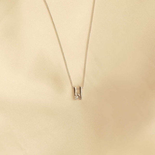 Flat lay shot of W Initial Pendant Necklace in Silver